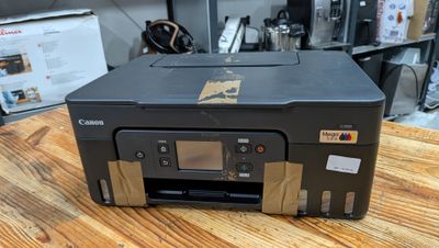 a canon printer sitting on a wooden table in a room