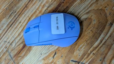 une souris bleue posée sur une table en bois