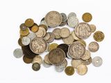 une pile de vieilles pièces de monnaie sur une surface blanche