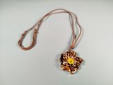a necklace with a flower on it on a white surface