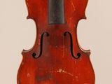 an old violin sitting on top of a white surface