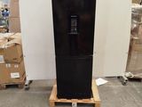 a black refrigerator sitting on a pallet in a warehouse