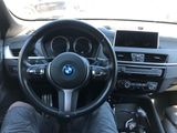 someone is sitting in the driver ' s seat of a bmw car
