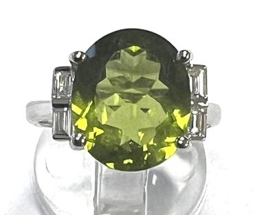 an image of a ring with a green stone surrounded by white diamonds