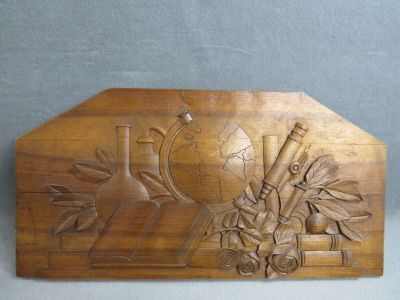 Panneau en bois sculpté aux attributs scientifiques.