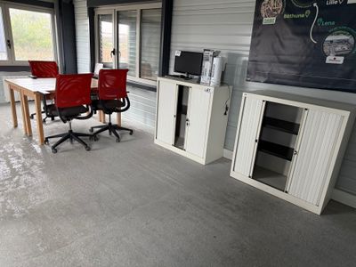 une pièce équipée d'une table, de chaises et d'un réfrigérateur