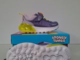 a pair of purple and yellow sneakers sitting on top of a box
