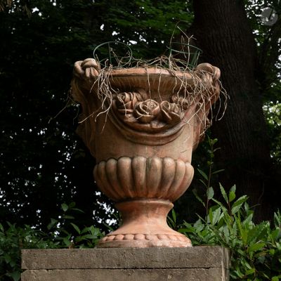un grand vase en pierre d'où sort une plante