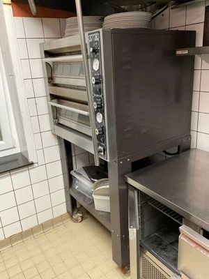une cuisine équipée d'une cuisinière, d'un four et d'étagères