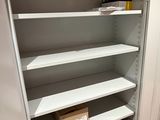 une armoire blanche avec des étagères, dans un coin de la pièce