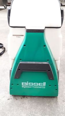 an image of a green and white floor scruber sitting on the ground