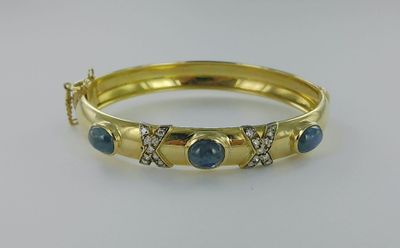 Bracelet rigide ouvrant or serti de trois saphirs cabochon e…