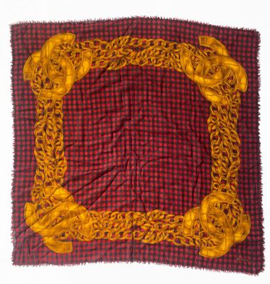 red and yellow square scarf with gold chains on a red and black checkered background