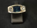 an image of a ring with a blue stone and three diamonds
