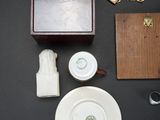 a small wooden box with a key, a plate, and other items on a table