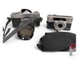 two cameras and a camera case on a white surface