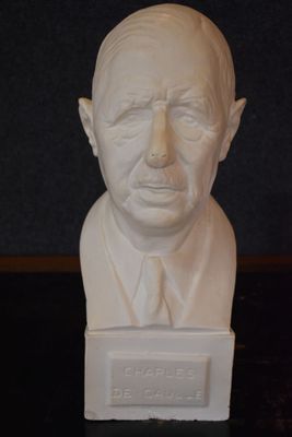 a bust of a man in a suit and tie on a table