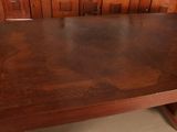 a wooden table with a brown top and a brown base