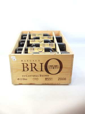 des bouteilles de vin dans une caisse en bois posée sur une surface blanche