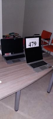two laptops sitting on a table in a room
