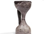 a gray vase that is sitting on a white surface