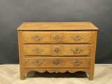 a wooden chest of drawers on a chevroned floor