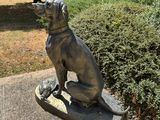 a statue of a dog sitting on top of a skateboard