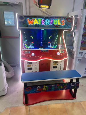 une photo d'une borne d'arcade miniature dans une pièce