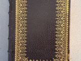 a black book with gold trim sitting on top of a table