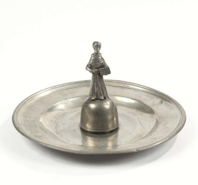 un plateau en argent sur lequel est posée une figurine