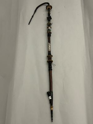 an old wooden stick with a metal handle on a white surface