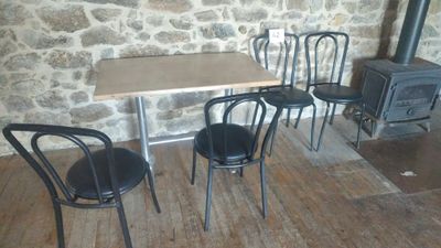 three chairs and a table in front of a wood burning stove