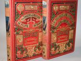 two red books are sitting on a white surface