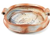 a brown and white bowl on a white surface