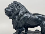 a statue of a lion that is standing on top of a rock