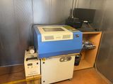 une machine bleue et blanche dans une pièce où se trouve un ordinateur