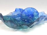 a blue glass bowl that is sitting on a table