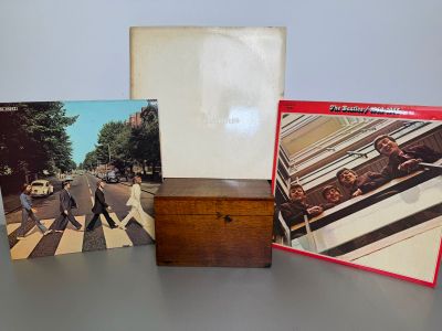 three beatles albums are sitting on a table next to a wooden box