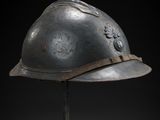 an old helmet on a stand against a black background