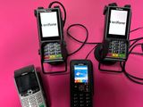 trois téléphones portables sont branchés sur un chargeur posé sur une surface rose