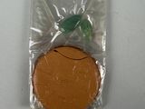 une petite orange dans un sac en plastique posé sur une table