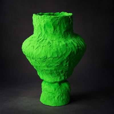 un vase vert posé sur une surface noire