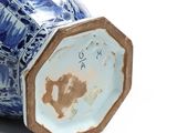 a blue and white vase with a lid sitting on a white surface