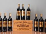six bouteilles de vin sont alignées sur une table, à côté d'une caisse en bois