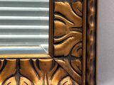 a picture of a gold framed mirror on a white wall