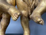 a statue of two children holding hands on a black base