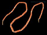un gros plan d'un collier composé de perles orange sur fond noir