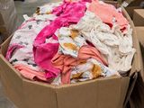 a cardboard box filled with lots of clothes in a warehouse
