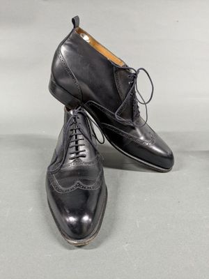 a pair of black leather shoes with laces on them