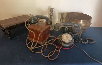 une table bleue sur laquelle sont posés plusieurs téléphones anciens
